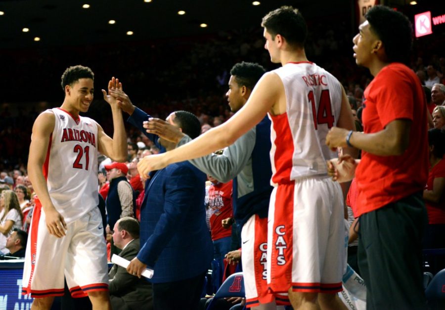 Arizona center Chance Comanche (21) gets a high-five from assistant coach Emanuel Richardson on Thursday, Jan. 28 in McKale Center. The Wildcats avoided losing three straight by pouncing Oregon State 80-63 on Saturday. 
