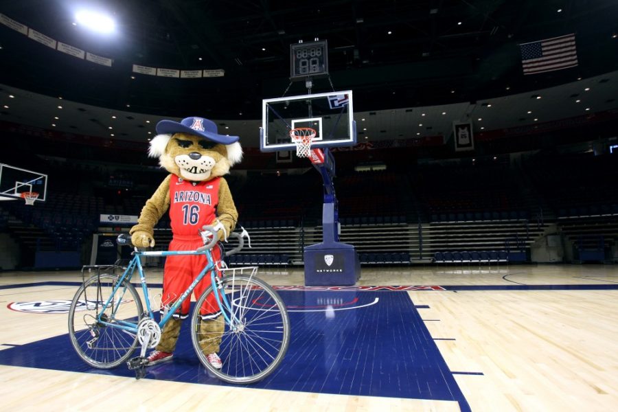Joe Previte stands as Wilbur with his bike in McKale Center on Thursday, April 21. Previte has worn the Wilbur suit for the 2015-2016 season and plans to ride across the country on his bike this summer.