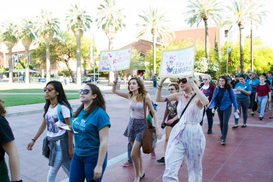 Protestors hold up Sailormoon-themed signs during the Take Back the Night March on Tuesday, April 12. 