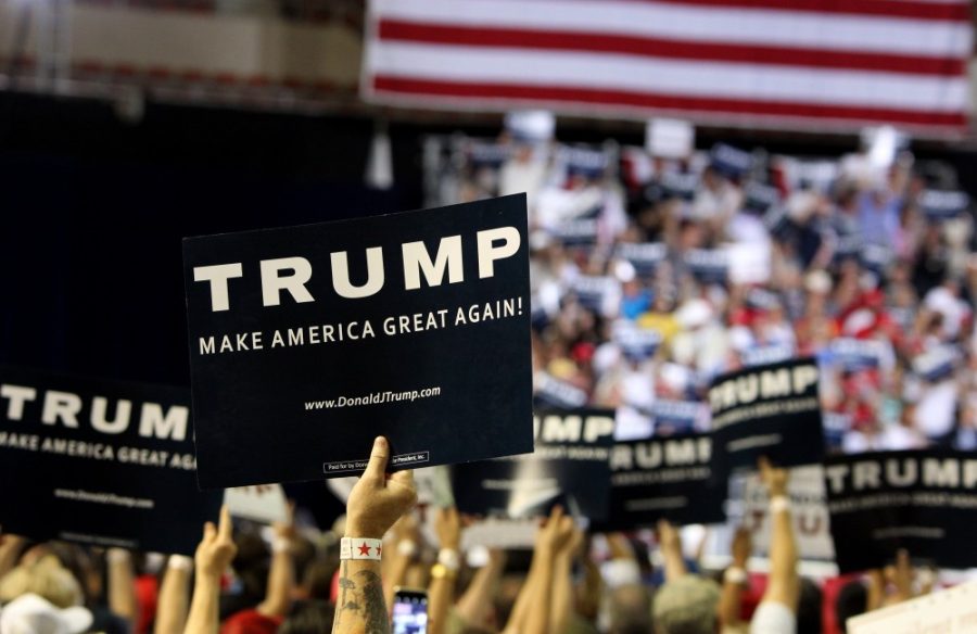 Trump supporters hold up signs at a rally in Phoenix on Saturday, June 18 at the Arizona Veterans Memorial Coliseum. 