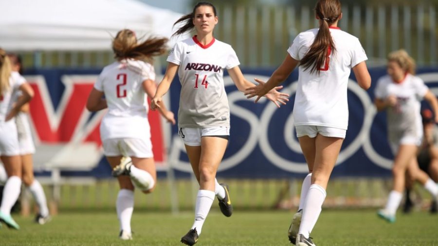 Arizona soccer player Jaden DeGracie-Bailey (left) high fives a fellow teammate. DeGracie-Bailey has 19 career assists, one shy of setting the school record.