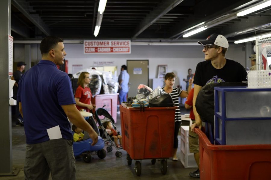 UA Surplus Property Storekeeper Luis Martinez helps out mechanical engineering junior Ben Mathews at the Wildcat Welcome Week Rummage Sale on Friday, Aug. 19. The majority of items at the UAs inaugural rummage sale soldout within three to four hours.
