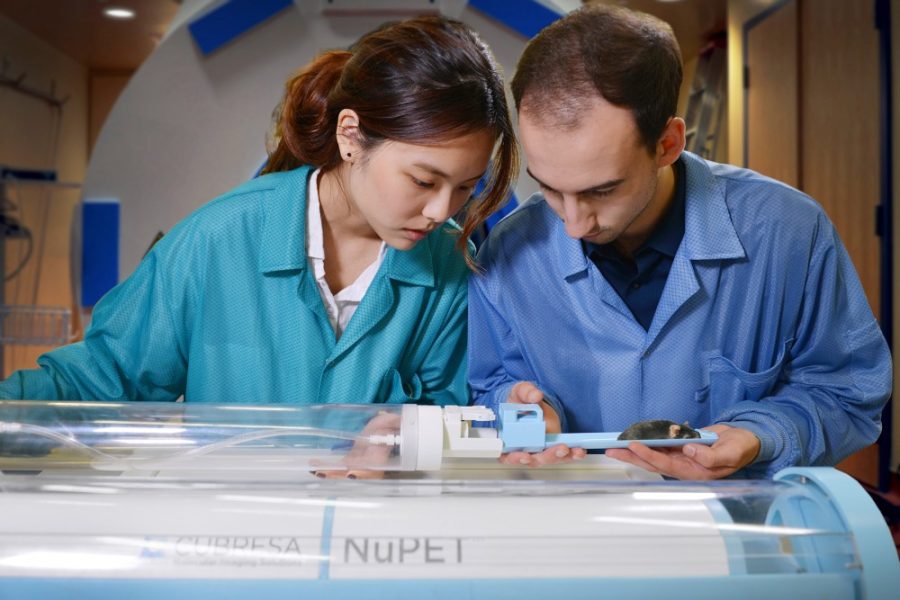 Two Cubresa researchers insert a mouse into the NuPET system on Thursday, July 28.