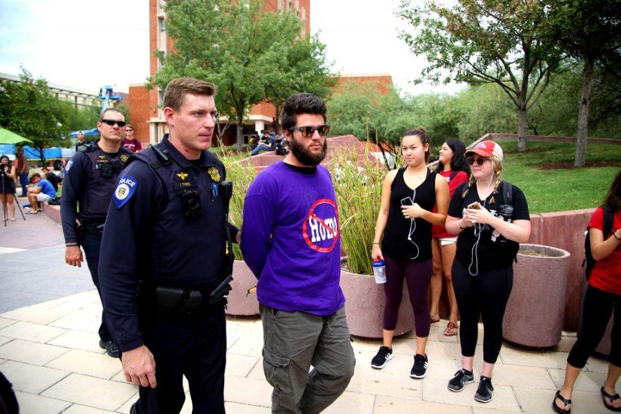 Officer Ian Theel leads Brother Dean to a Police Cruiser on Tuesday, Sept. 20th. Brother Dean was arrested on one count of assault for kicking a student. he has subsequently been kicked off campus for a year.