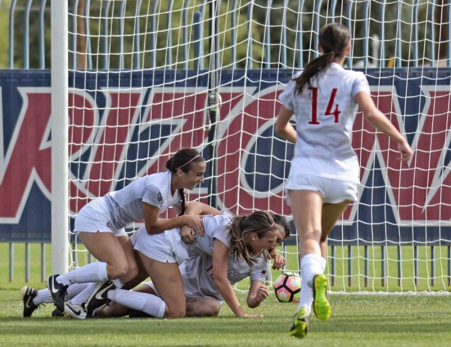 Arizona midfielder Gabi Stoian (9) and forward Paige Crouch (15) tackle Arizona midfielder Cali Crisler (3) in celebration after her game-winning goal in double overtime against California at Murphey Field at Mulcahy Soccer Stadium on Sunday, Oct. 30, 2016. The Wildcats triumphed over the Golden Bears 2-1.