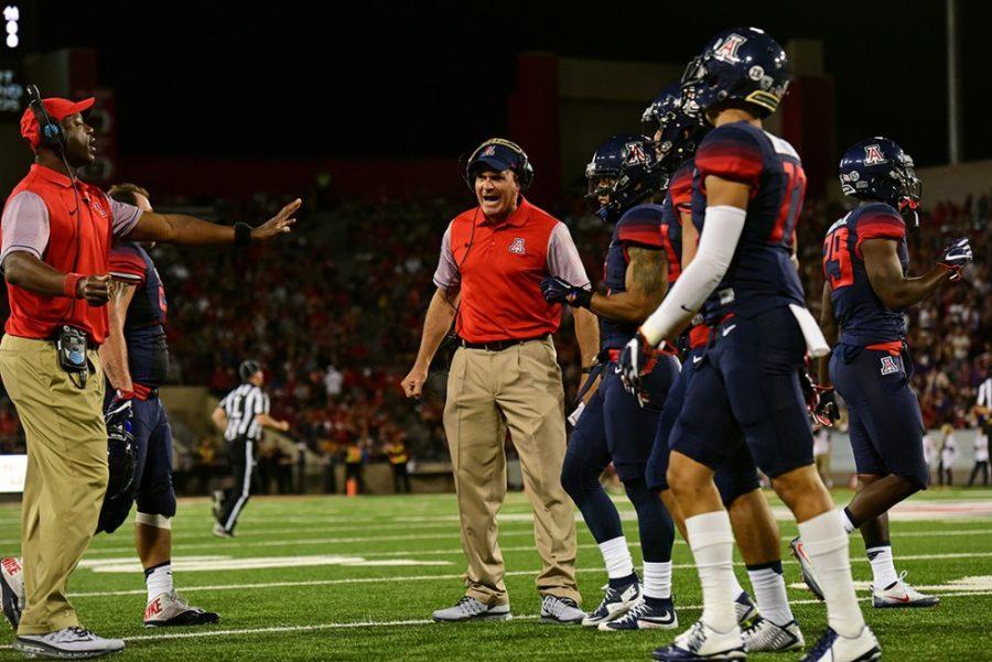 Head coach Rich Rodriguez, center, hollers as players head back to the sidelines during Arizonas overtime 35-28 loss to Washington in Arizona Stadium on Saturday, Sept. 24.