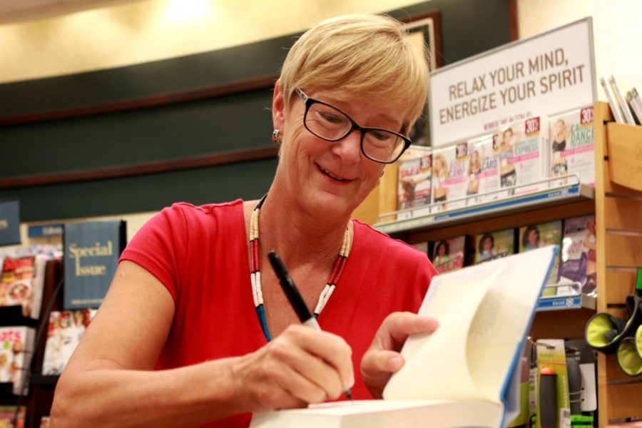 Shannon Baker, author of Stripped Bare cheerfully signs a copy of her book at her Barnes and Noble book signing in Tucson, Ariz. on Sunday, Oct. 2, 2016. 
