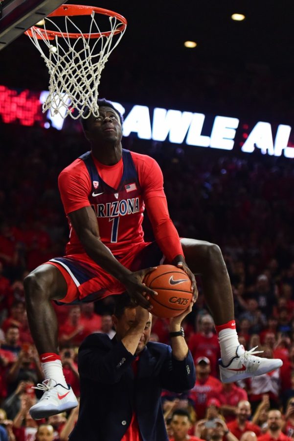 Arizona guard Rawle Alkins snags the ball from head coach Sean Millers hands for a dunk during the slam dunk completion before the red and blue scrimmage at McKale Center on Friday, Oct. 14, 2016. 
