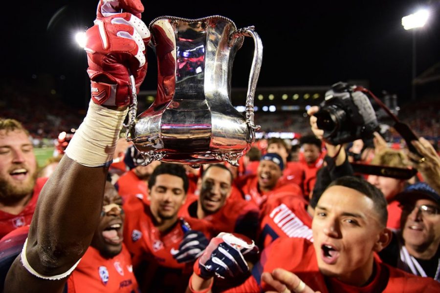 Victorious members of the Arizona football team hoist the territorial cup into the air in celebration after Arizonas 56-35 win against ASU in Arizona Stadium on Friday, Nov. 25, 2016.