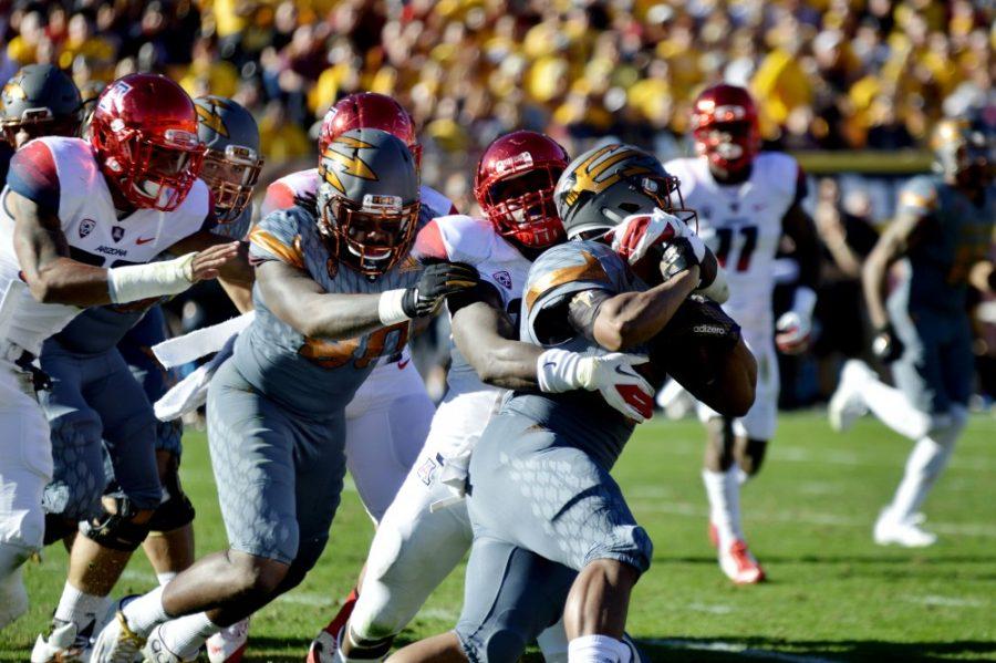 Arizona defenders pull down Arizona State player in the second quarter of the game on Saturday, Nov. 21, 2015.