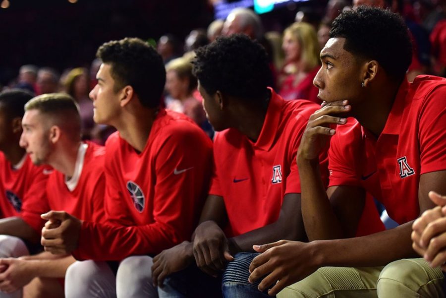 Arizona guard Allonzo Trier, far right, pensively sits on the bench in street clothes during Arizonas blow-out 86-35 exhibition win over the College of Idaho at McKale Center on Tuesday, Nov. 1, 2016. 