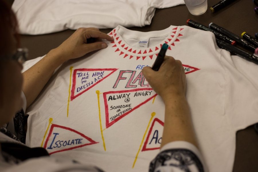 A gallery-goer decorates a shirt to hang for the Clothesline Project installation at the Galleria at the YW, Jan. 6. Shirts are decorated to represent instances of sexual and domestic violence in the decorators life.