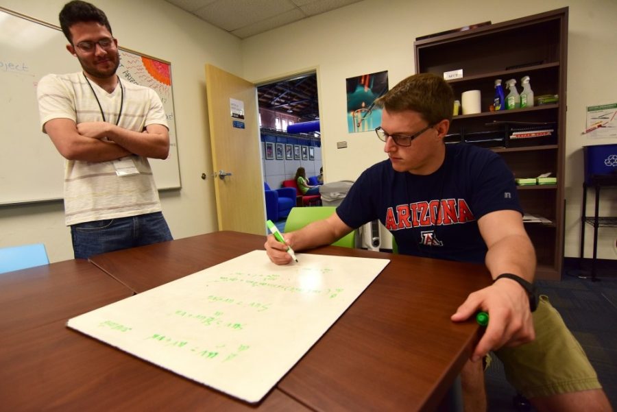 Tutor Alberto Carazo Diaz (left) looks on as fellow tutor Jared Irwin (right) tries to work out a step-by-step method to solve a calculus II problem at the Think Tank in Bear Down Gym on Monday, July 18, 2016. There are five Think Tank locations throughout campus in Bear Down Gym, Park Student Union, Student Rec Center, Manzanita-Mohave Hall and Coronado Hall.