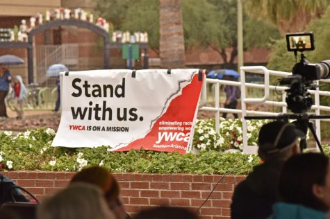 A "Stand With Us" sign hung up at the "Teach-In and March" even held on the UA Mall on Jan. 20. Events protesting Donald Trump's inauguration took place locally and around the world.
