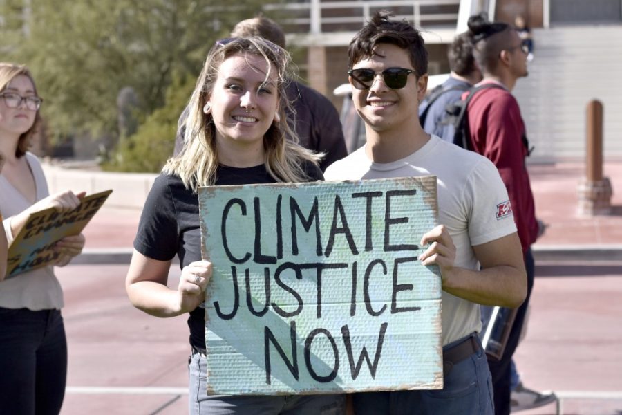 Kashja Iler, a first-year grad student in the school of natural resources and development, and Diego Martinez-Lugo, a senior majoring in environmental studies and geography, hold up a sign during the climate walkout on Jan. 23. The walkout is one of many around the country, organized by 350.org.