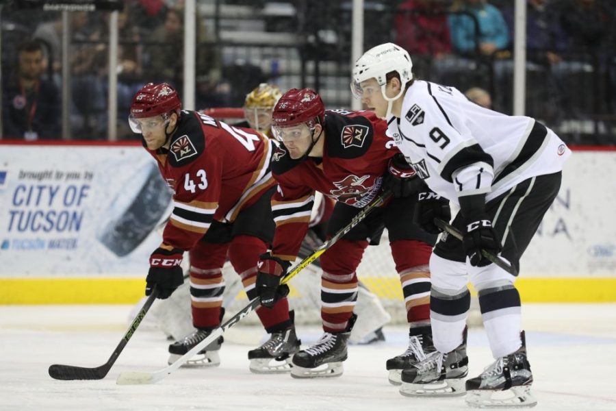 Roadrunners Christian Fischer and Dakota Mermis line up for a faceoff with Ontario Reign forward Cameron Schillings.