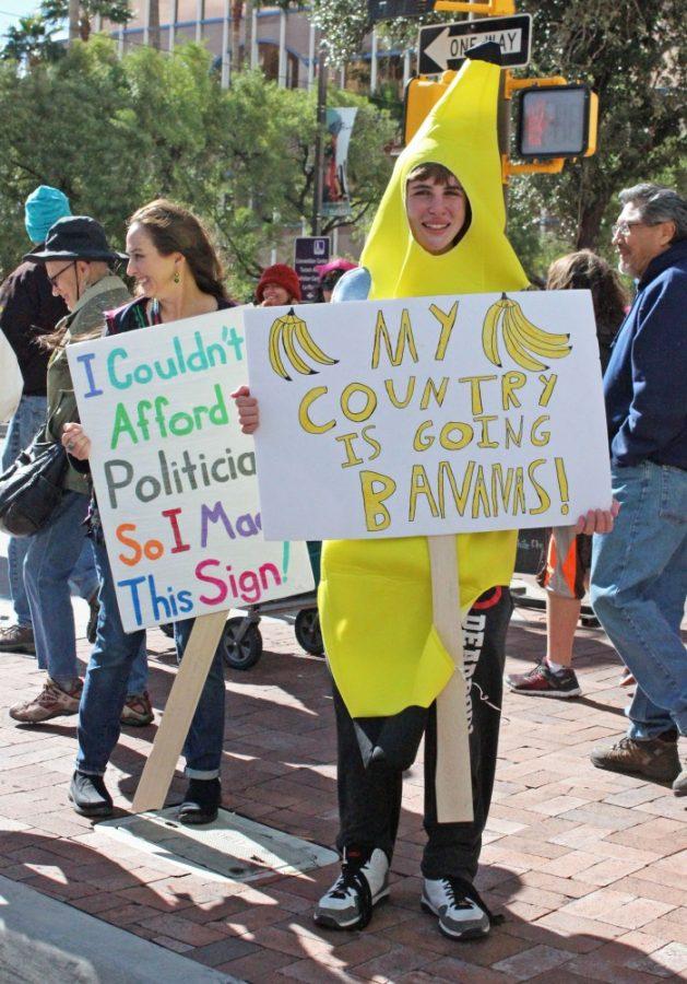Two protesters hold up their signs during the Womens March on Washington in downtown Tucson on Jan. 21. One of the best ways for students to become politically engaged is to participate in events like this one.