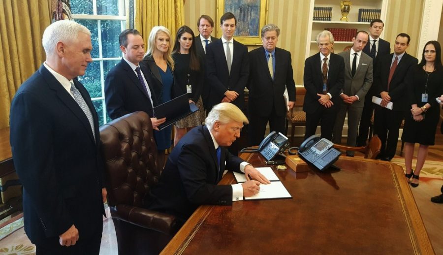 President Donald Trump signing executive orders in the Oval Office on Jan. 24. Trumps revised executive order barring entry from several Muslim countries will go into effect March 16.