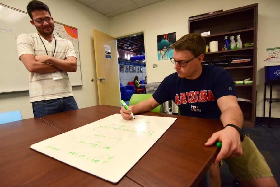 Tutor Alberto Carazo Diaz (left) looks on as fellow tutor Jared Irwin (right) tries to work out a step-by-step method to solve a calculus II problem at the Think Tank in Bear Down Gym on Monday, July 18, 2016. Funded by increased student fees, an upcoming expansion of Bear Down Gym will include a new three-story facility and other improvements.