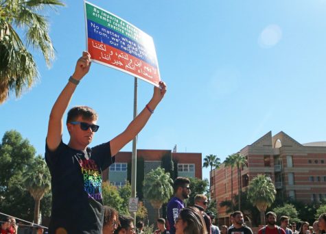 Freshman law major, Mat Schildt, holds up a poster in front of Brother Dean Saxton on Thursday, Sept. 28. With the expiration of his one-year ban from the UA campus for assault, Saxton was allowed to return this week.