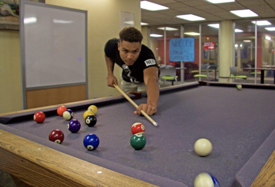 Nick Griffin concentrates on making his next shot during pool, one of the many activities that freshman can do in their dorms.