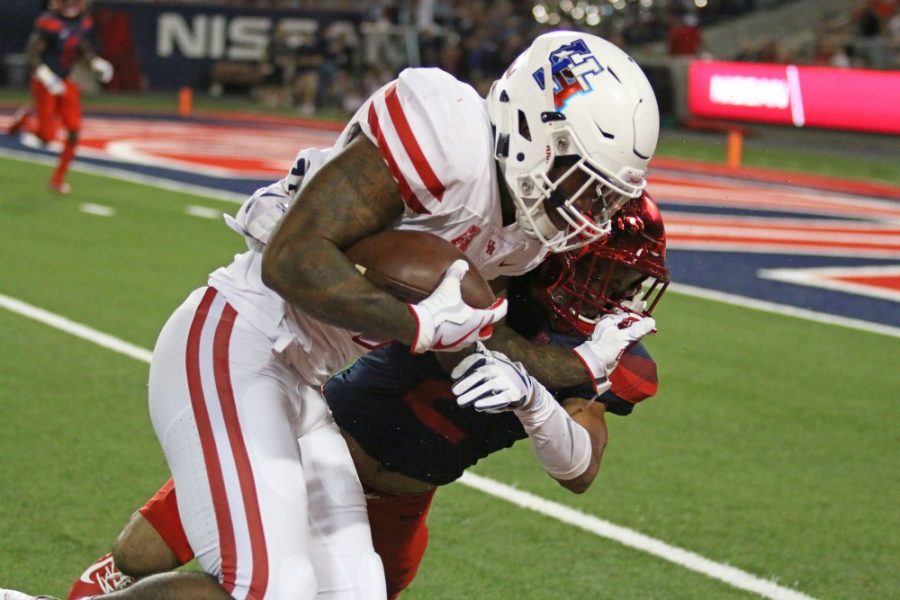 A Houston player pushes past an Arizona defender during the UA-Houston game at Arizona Stadium on Sept. 9.