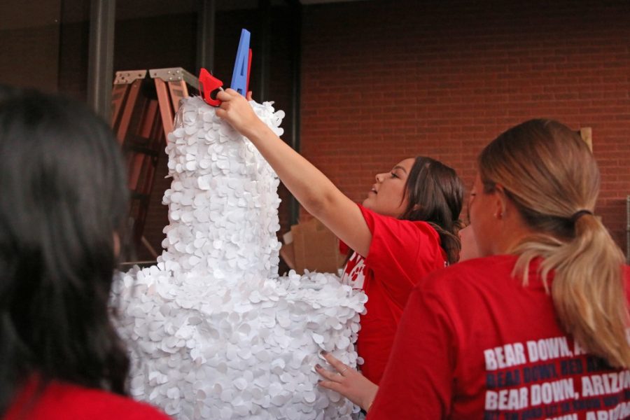 UA sophomore Bailey Grijalva, center, positions props on the SAA float birthday cake. The UA Alumni Assocation will be celebrating its 120th birthday this Homecoming.