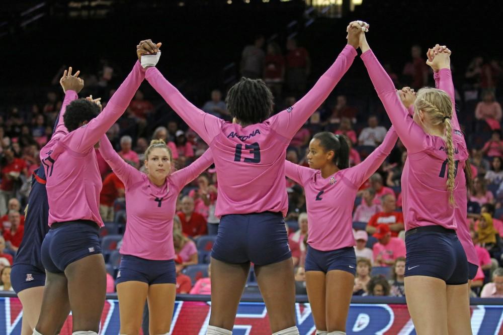 The Arizona volleyball team holds hands before their game against Utah on Oct. 13 in McKale Center.
