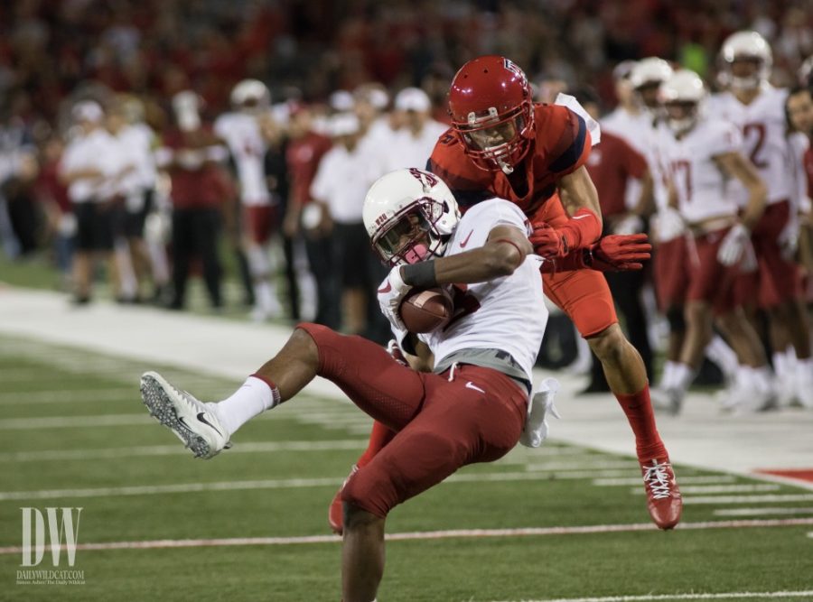 A Washington State player is taken down by an Arizona player during the UA-Washington State game on Saturday, October 28.