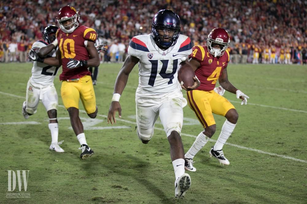 Arizona's Khalil Tate (14) runs out of bounds to avoid a tackle during the final quarter of the UA-USC game.