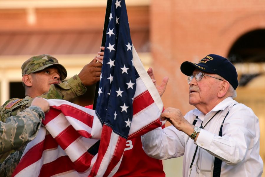 World War II veteran Stuart Moser, right, helps staff sergeant Cruz  Garcia, left, retire the Old Glory Relay flag until the next morning in  front of Old Main on Oct. 5, 2016. Events began on ​Nov.​ ​6 ​with​  ​the​ ​Veterans​ ​of​ ​All​ ​Eras​ ​meet​ ​and​ ​greet. 