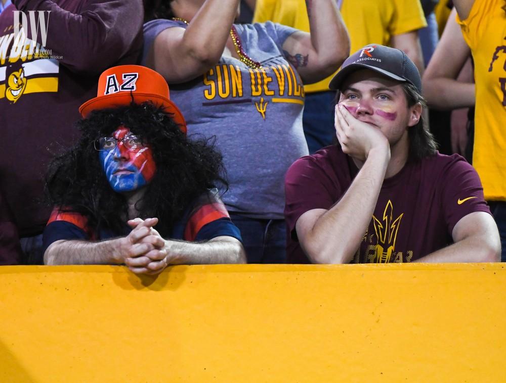 An Arizona fan sits with an Arizona State fan during the UA-ASU rivalry game on Nov. 25 at Sun Devil Stadium.