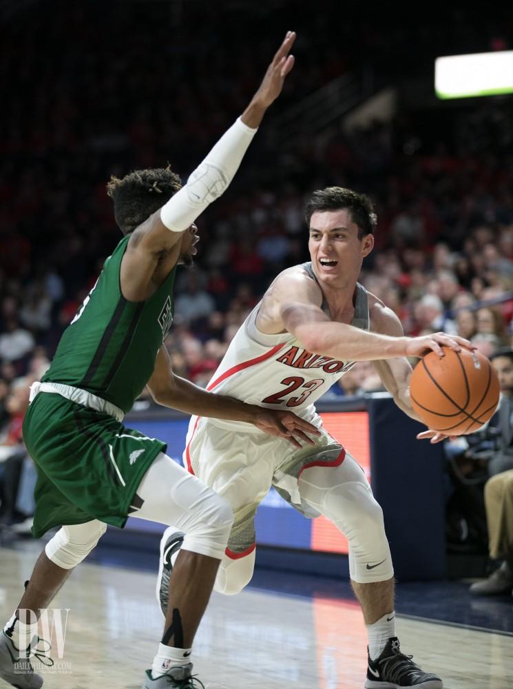Arizona's Alex Barcello tries to pass the ball behind an ENMU defender. Barcello ended the night with 7 points.