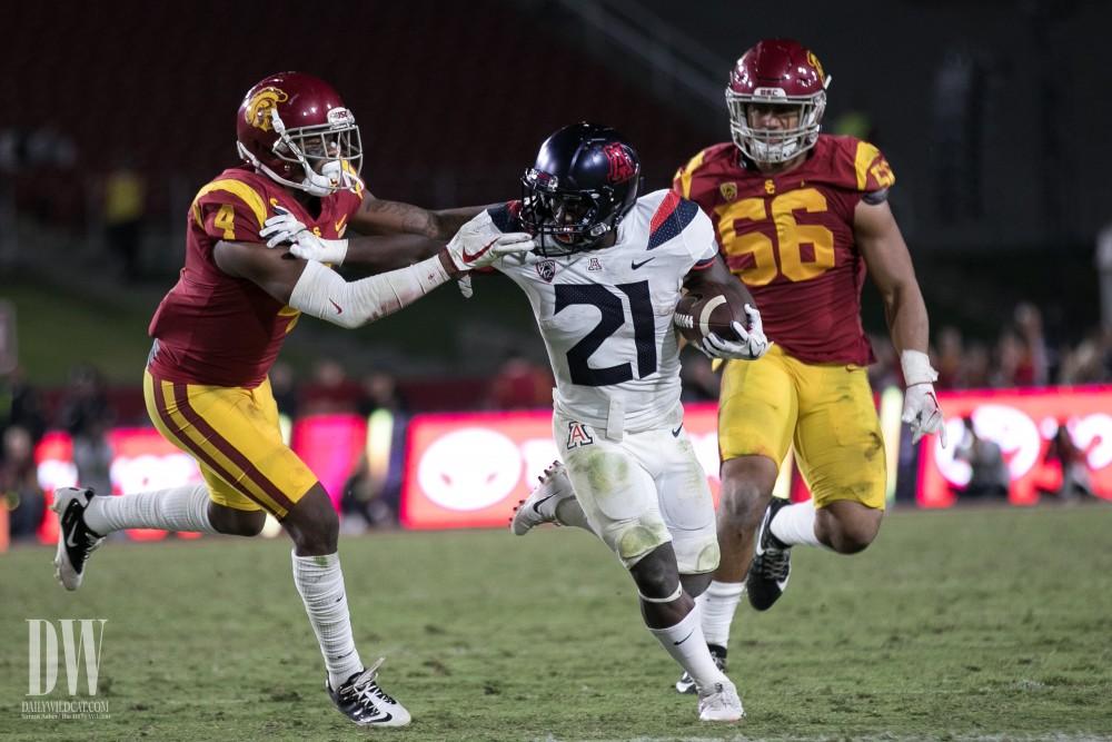 Arizona's J.J. Taylor pushes aside USC's Chris Hawkins (4) while running towards the end zone.