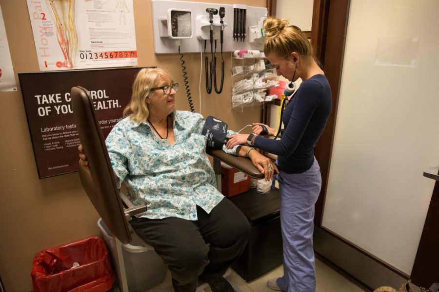Cassandra Paral, right, takes the blood pressure of Susie Hathaway, left, on Aug. 20 at Banner Quick Care. UA researchers have received a $10 million grant to study the relationship between the human immune system and aging. 