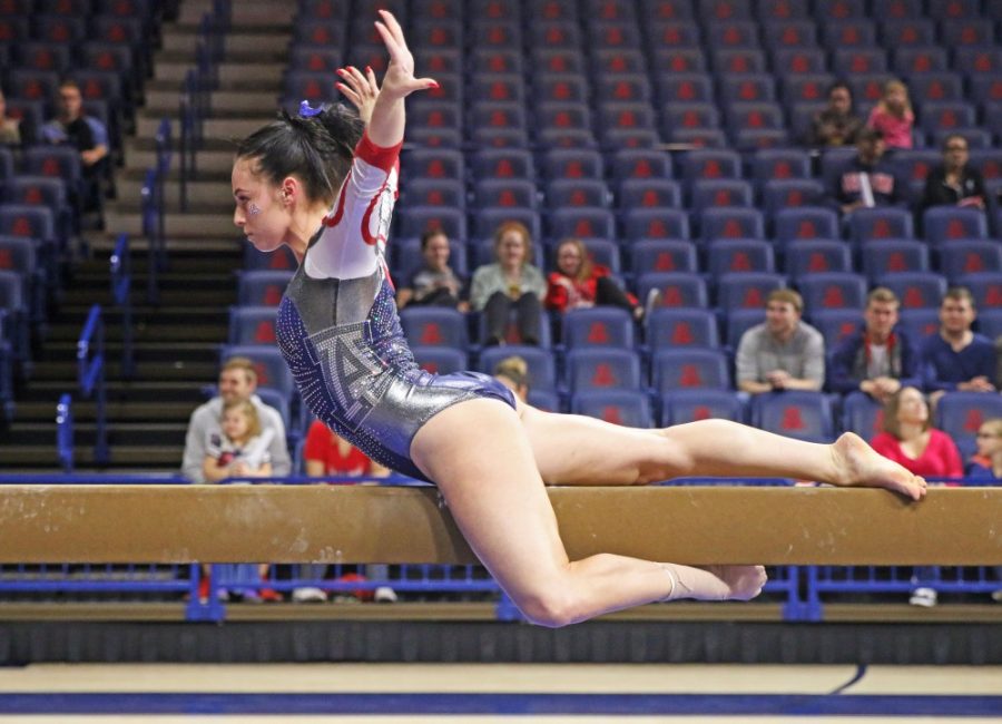 UA gymnast Victoria Ortiz strikes a pose on the balance beam during the GymCats Showcase on Dec. 5 in McKale Center. 
