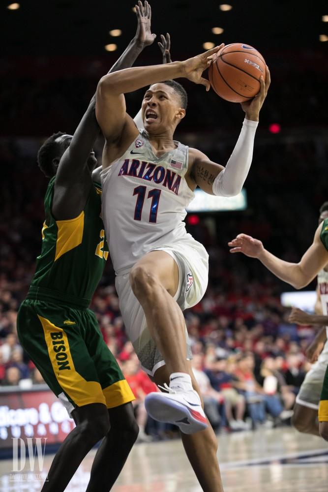Arizona's Ira Lee muscles past North Dakota's Deng Geu. Lee had four points and four rebounds.