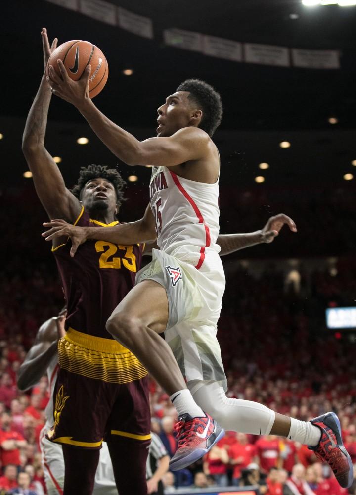 Arizona's Allonzo Trier jumps to lay in the ball over Arizona State's Romello White. White fouled out in the second half with two points.