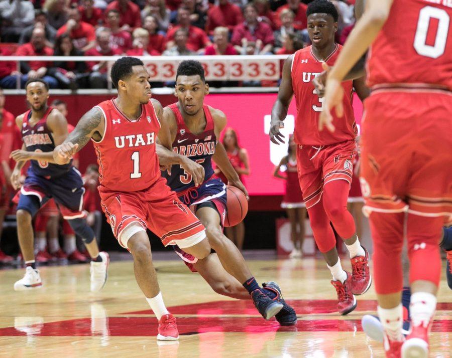 Arizonas Allonzo Trier does a behind-the-back crossover to get past Utahs Justin Bibbins (1).