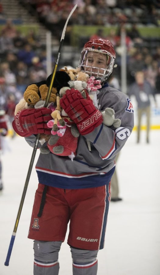 Arizonas Tyler Griffith brings an armful of tossed teddy bears between the first and second period.
