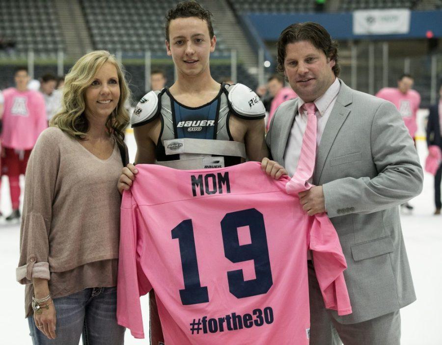 Arizonas+Justin+Plumhoff+and+Head+Coach+Chad+Berman+hold+up+a+jersey+honoring+Plumhoffs+mother+and+her+fight+with+cancer.+All+jerseys+worn+by+Arizona+were+pink+to+honor+those+with+cancer.