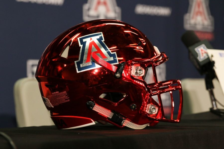 A UA football helmet sits on the press conference table after the conference concludes.