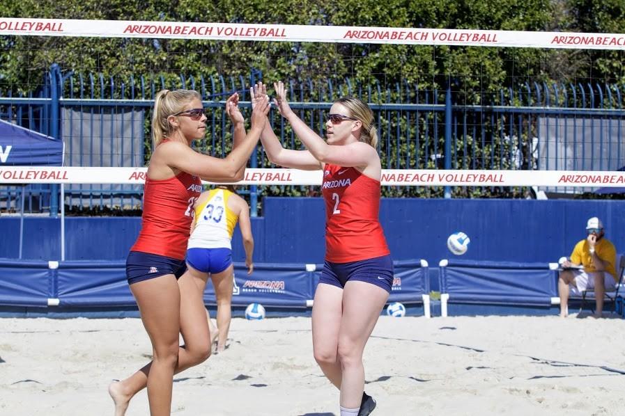 Arizona’s Makenna Martin (2) and Caroline Cordes (25) high five and get ready for the next play after scoring a point against their San Jose State opponents on Sunday Feb. 25 at Bear Down Beach in Tucson, Ariz.