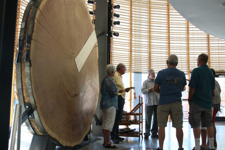 Randall Smith, lead docent of the UA Laboratory of Tree Ring Research, and a tour group stand next to a cross section of a Giant sequoia on Tuesday, Feb. 6. Tree rings are useful for more than just determining the age of a tree; scientists can conclude a wide range of environmental variables both past and present by analyzing tree rings.
