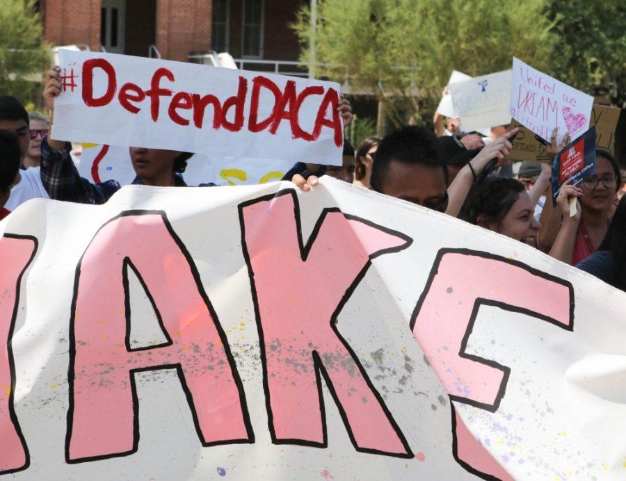 Protesters participate in chants and hold up signs in front of Old Main during the pro-DACA protest on Sept. 5, 2017.