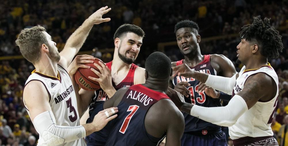 Arizona's Dusan Ristic holds onto the ball amid a tangle of teammates and opposing Arizona State players during the Arizona-Arizona State game on Thursday, Feb. 15 in Wells Fargo Arena in Phoenix, Ariz.