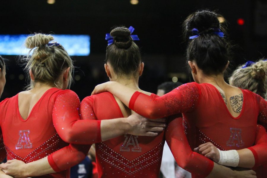 The UA Gymnastics team huddles together after completing the second rotation of the UA v UNC, SJSU, and Air Force meet on March 9th in McKale Center.