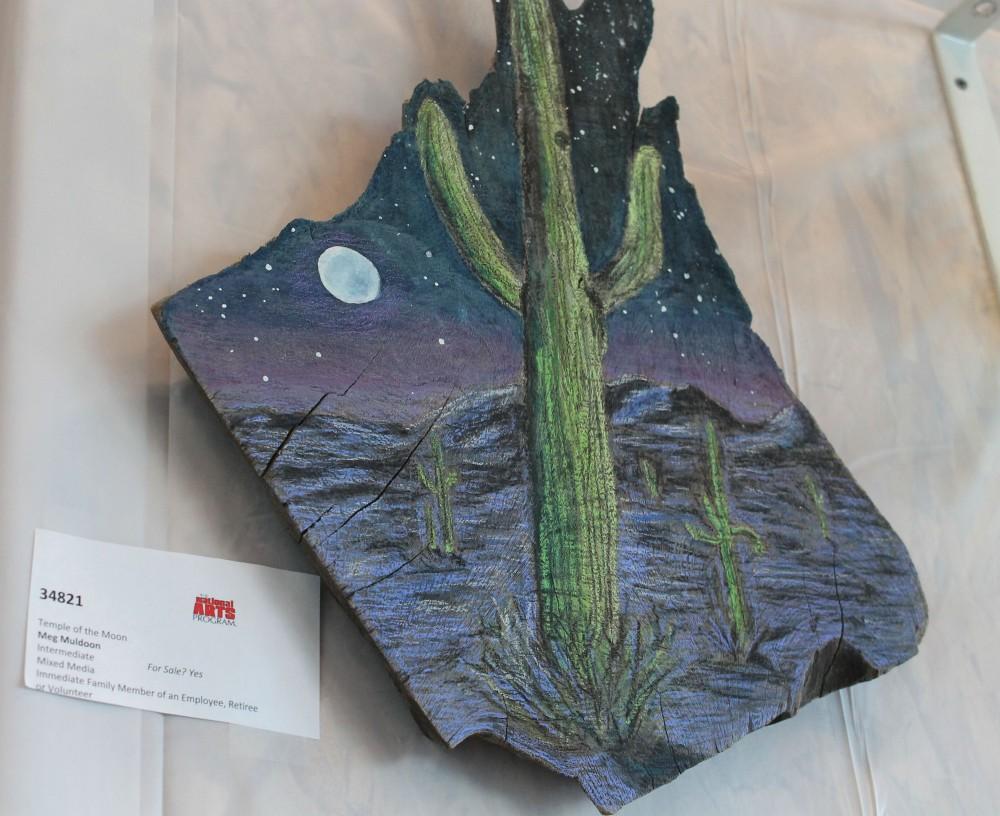 "Temple of the Moon" by Meg Muldoon on display at the 'On Our Own Time' exhibit. This art piece is a mix media piece painted on a slab of wood and is available for purchase. 