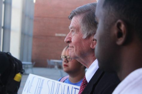 Arizona Board of Regents chair Bill Ridenour, center, stands with DACA protesters outside of the ABOR meeting on Nov. 16.