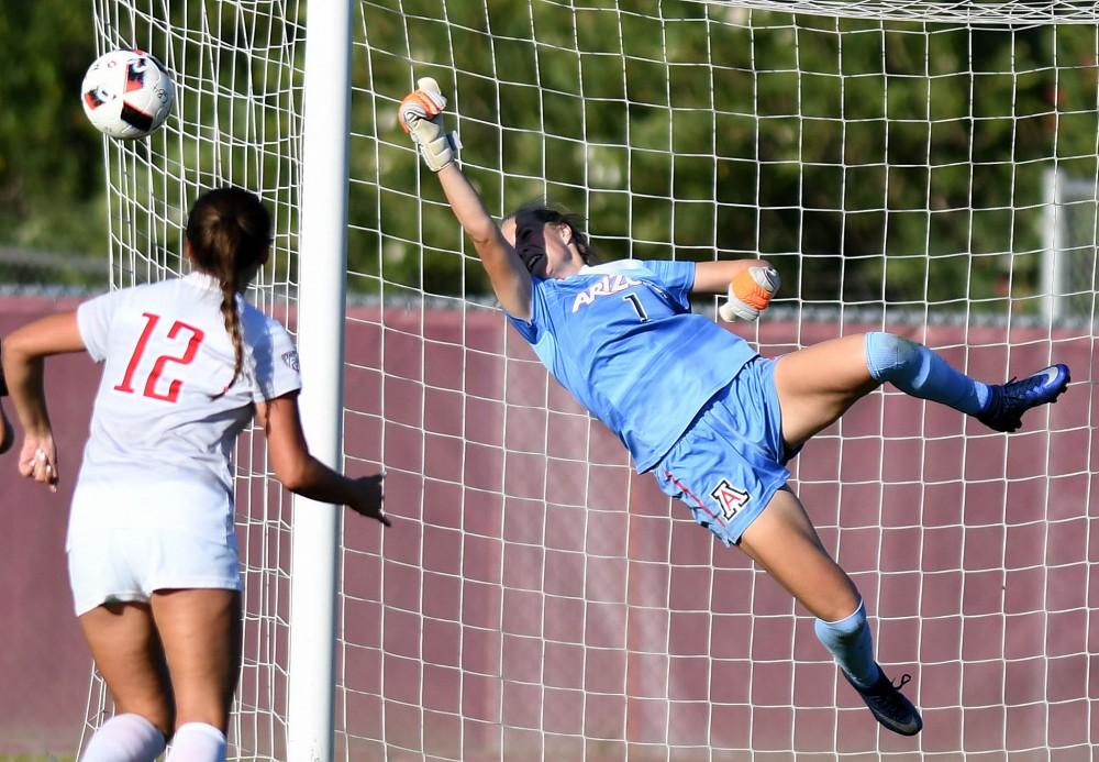 Arizona goalkeeper Lainey Burdett (1) flies to punch the ball away after a shot by ASU at Sun Devil Soccer Stadium in Tempe on Friday, Nov. 4, 2016. The Wildcats shut out the Sun Devils 1-0 for their first Territorial Cup win in soccer since 2013.